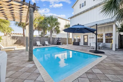 a view of a swimming pool with a table and chairs under an umbrella