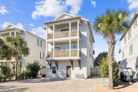 a white building that has a tree on the side