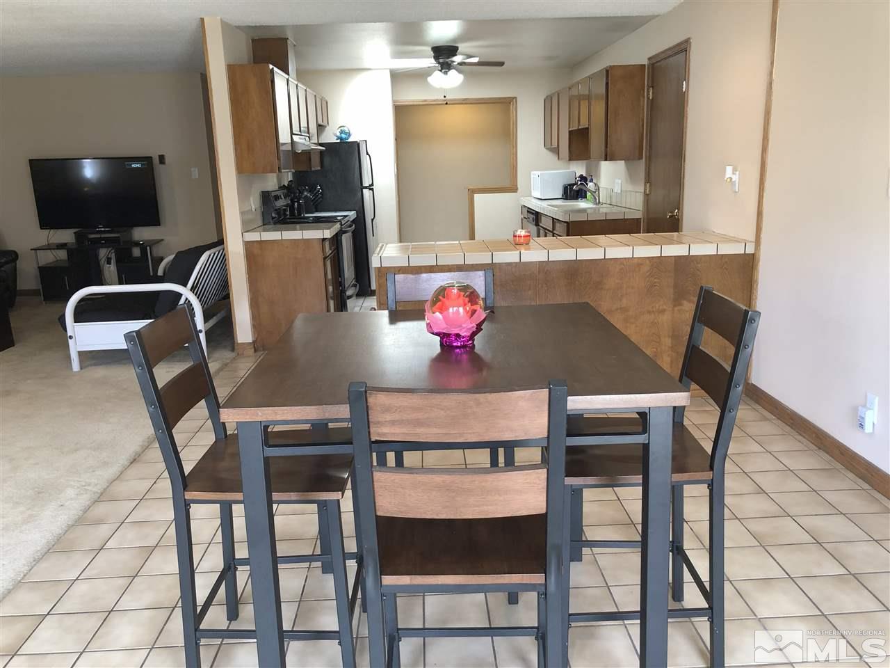 3351 Bryan Street Reno, NV 89503 - Photo 10 of 24 a kitchen with stainless steel appliances granite countertop a dining table chairs and a refrigerator