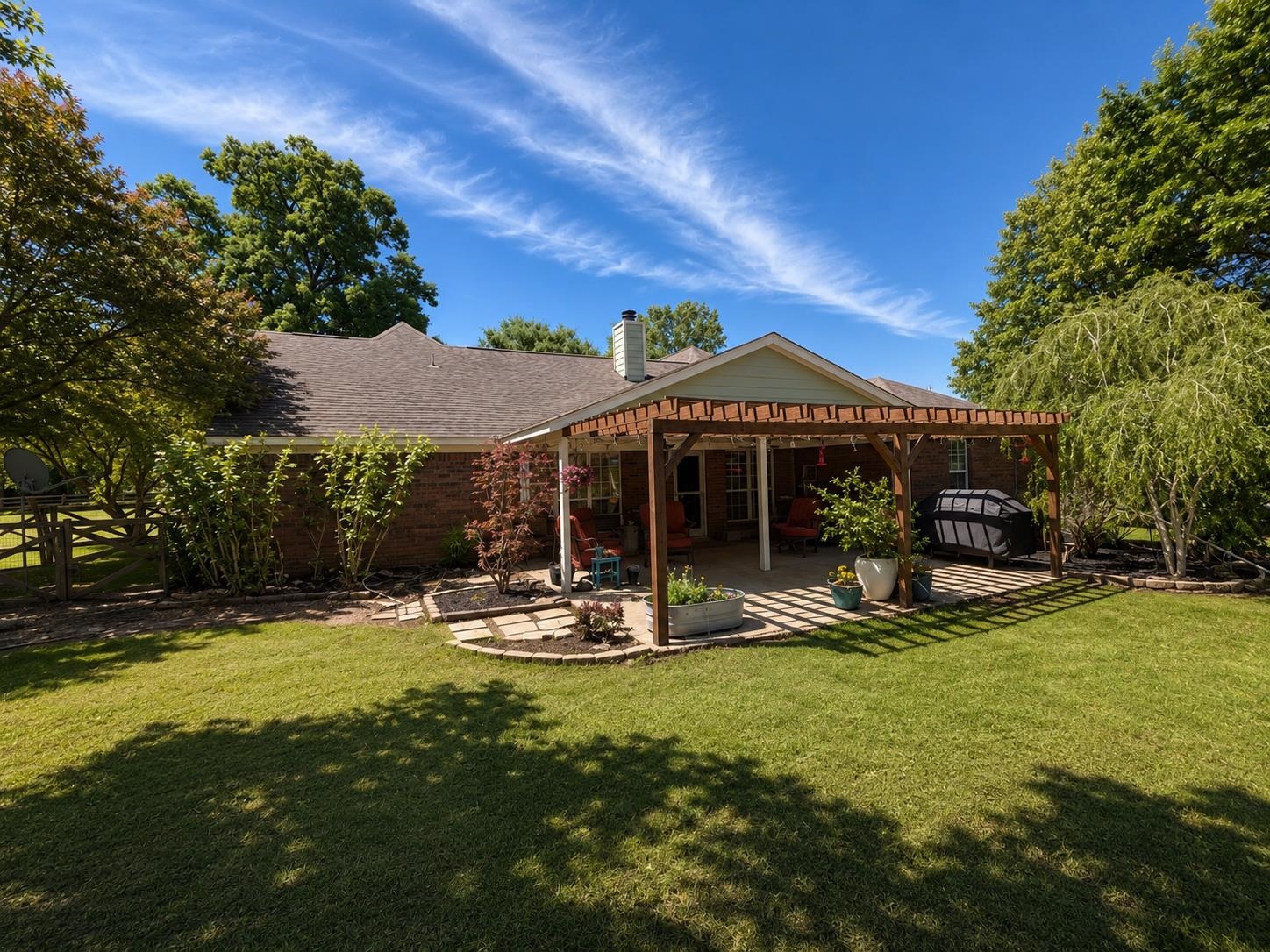 1946 Little John Road Millington, TN 38053 - Photo 14 of 20 Expansive backyard featuring a manicured lawn, brick exterior, covered patio, and a wood pergola