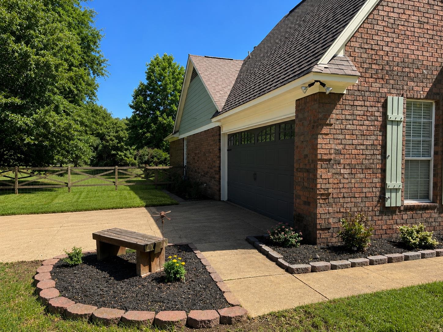 1946 Little John Road Millington, TN 38053 - Photo 19 of 20 Brick exterior with a dark garage door, light green board and batten shutters, and a concrete driveway