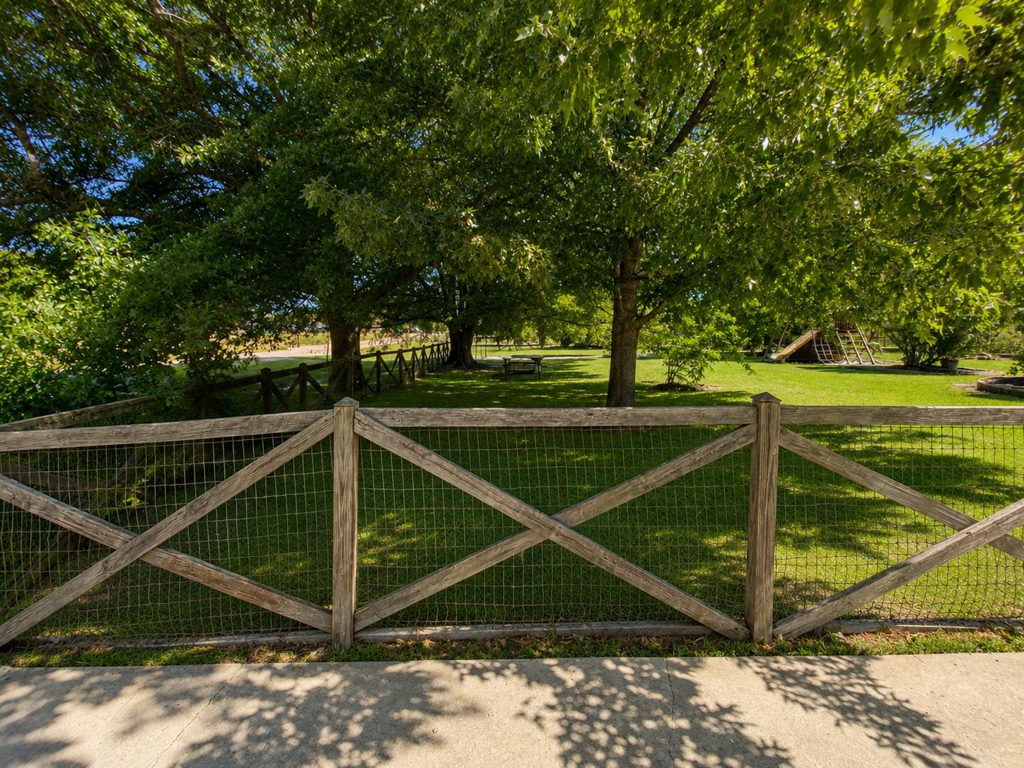 1946 Little John Road Millington, TN 38053 - Photo 20 of 20 Expansive green space featuring a wooden fence with wire mesh, mature trees, and a concrete pathway