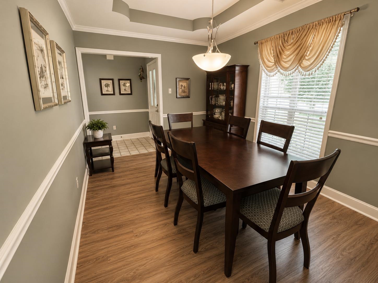 1946 Little John Road Millington, TN 38053 - Photo 3 of 20 Dining area featuring wood-finish flooring, a tray ceiling, and a large window with blinds