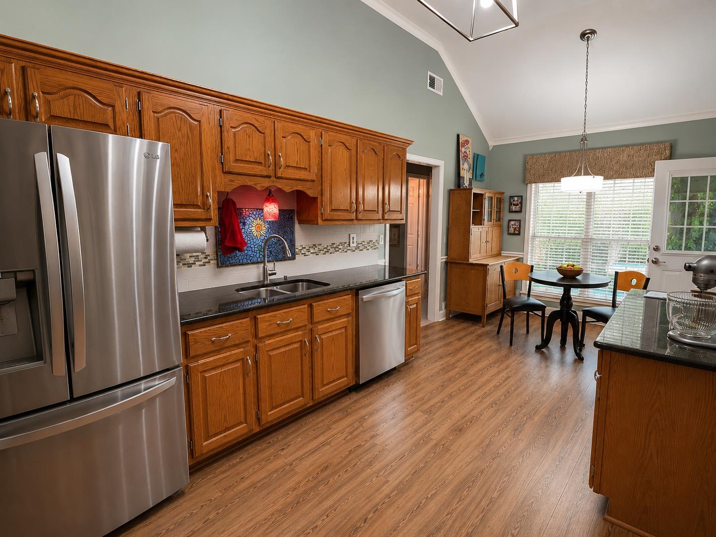 1946 Little John Road Millington, TN 38053 - Photo 6 of 20 Kitchen featuring wood-finish flooring, vaulted ceiling, and light green wall tones
