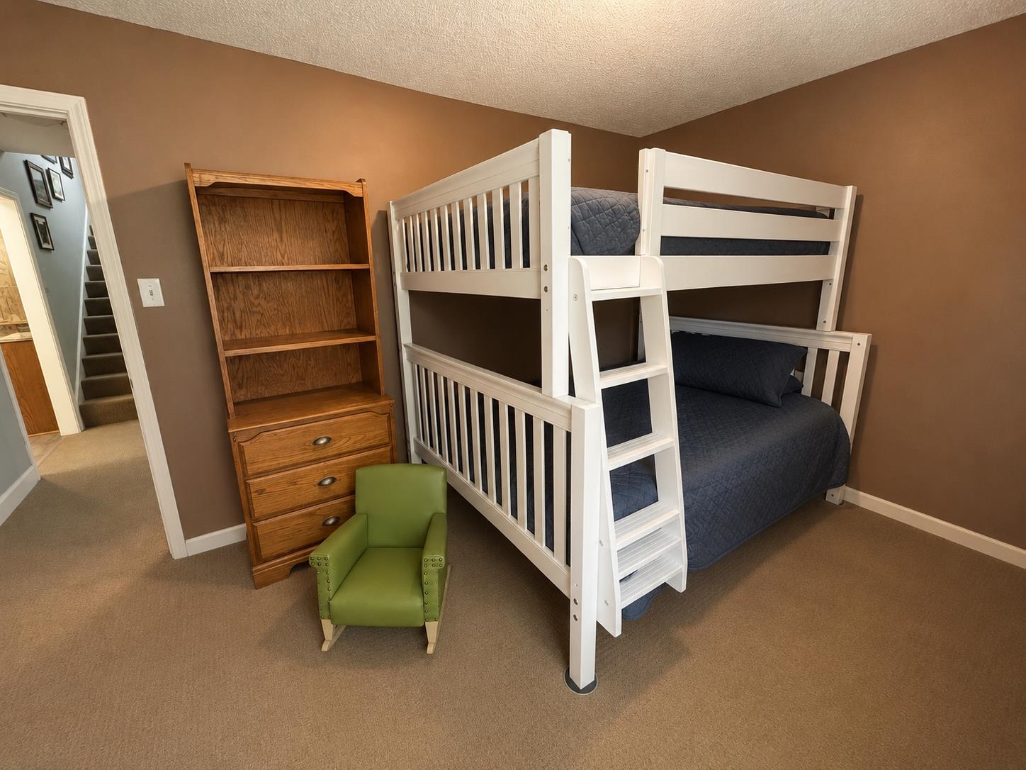 1946 Little John Road Millington, TN 38053 - Photo 9 of 20 Carpeted room featuring a white bunk bed with integrated ladder, a wooden bookcase with drawer storage, and warm-toned wall paint