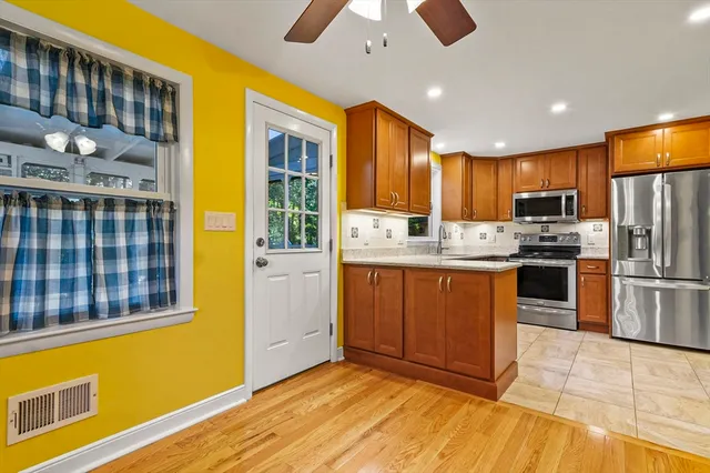 a kitchen with stainless steel appliances granite countertop a refrigerator and a stove top oven