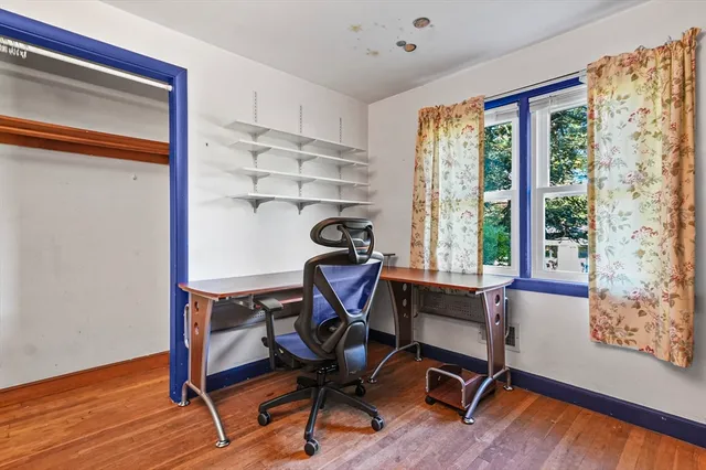 a view of a workspace with furniture and a window