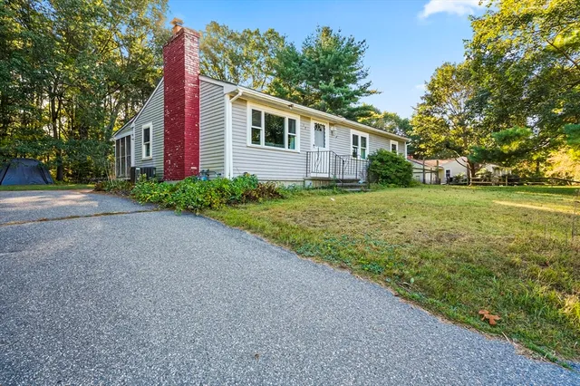 a view of a house with backyard and trees