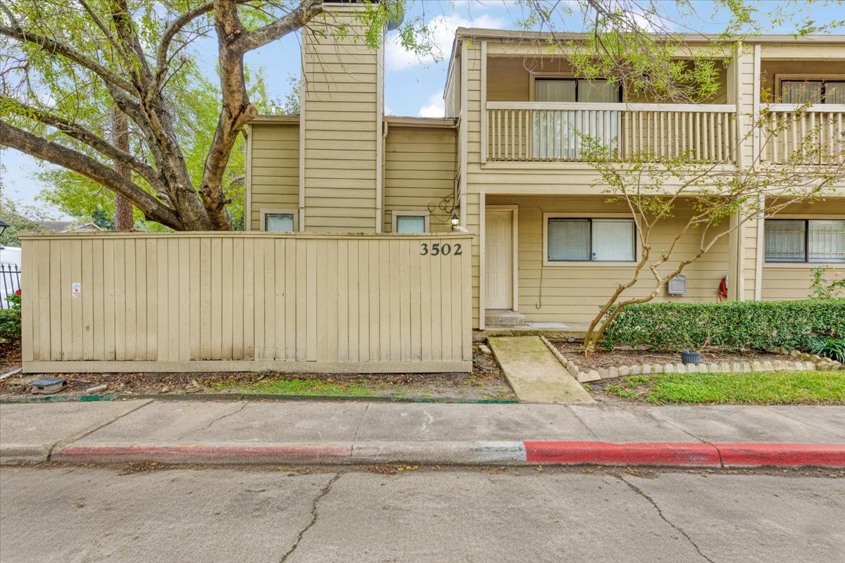 3502 Ocee Street, Unit 3502 Houston, TX 77063 - Photo 27 of 28 This is a charming two-story townhouse with a private patio, mature trees, and a balcony. The exterior features a neutral color scheme and well-maintained landscaping, offering a welcoming entrance.