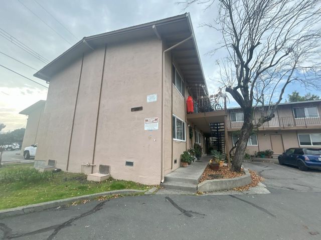 a view of a building with sitting area and garden