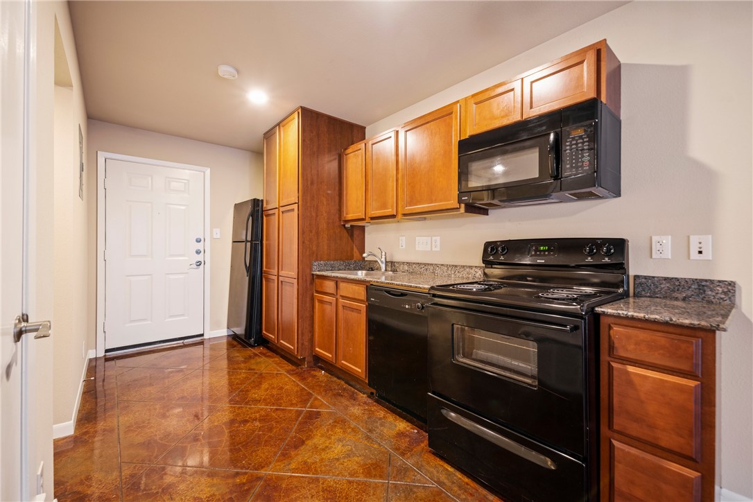 301 West 38th Street, Unit 106 Austin, TX 78705 - Photo 9 of 16 a kitchen with stainless steel appliances granite countertop a stove microwave and refrigerator