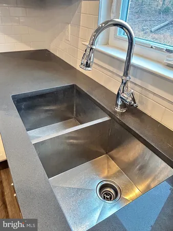 a view of large kitchen with large windows and wooden floor