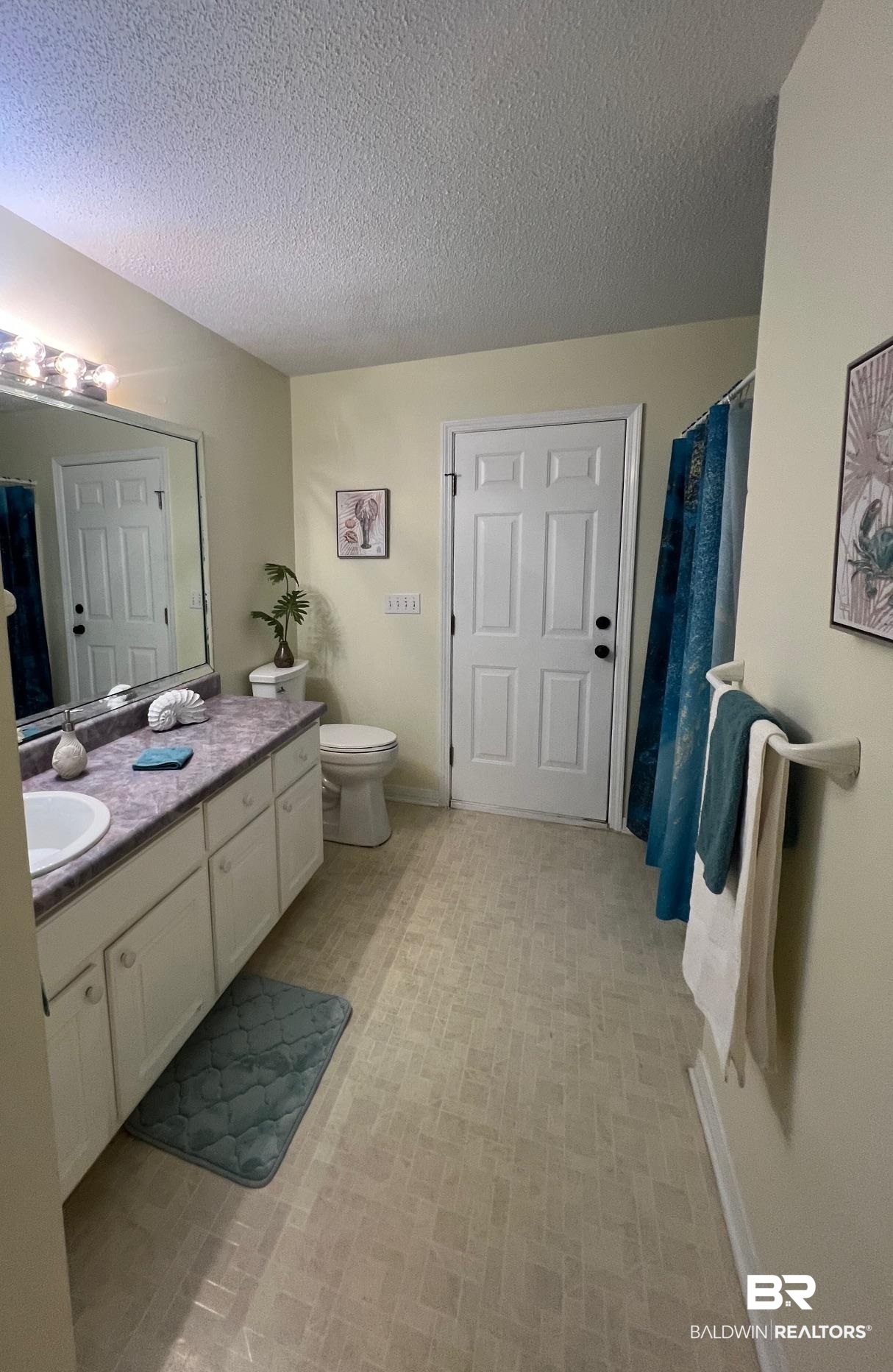 2204 Club House Drive Lillian, AL 36549 - Photo 17 of 38 Full bathroom with vanity, a textured ceiling, and a shower with curtain