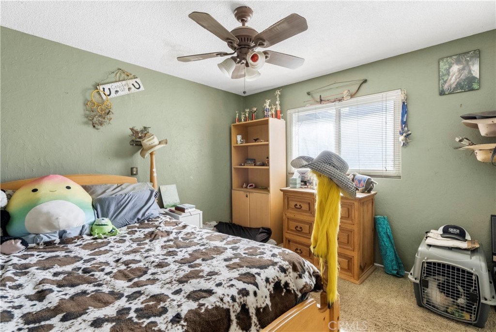 172 Eighth Street Norco, CA 92860 - Photo 19 of 55 a bedroom with a bed and a chandelier