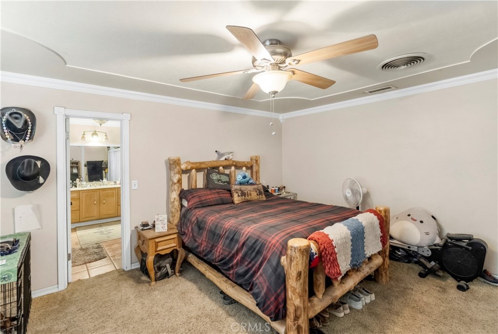 172 Eighth Street Norco, CA 92860 - Photo 22 of 55 a bedroom with a bed and a chandelier