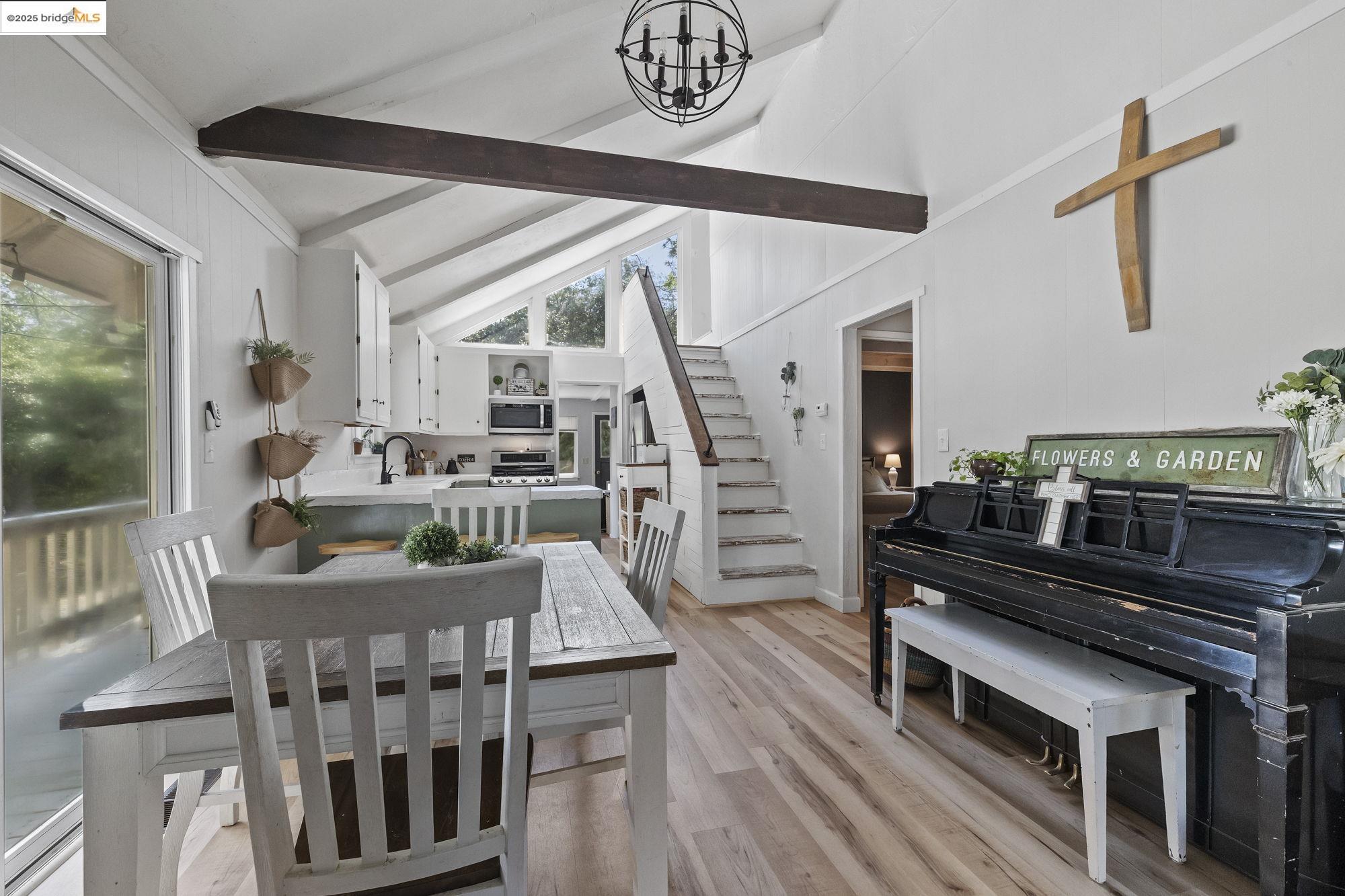 20638 Maranatha Road Tuolumne, CA 95379 - Photo 22 of 60 Dining space featuring light wood-style flooring, beam ceiling, stairway, a chandelier, and high vaulted ceiling