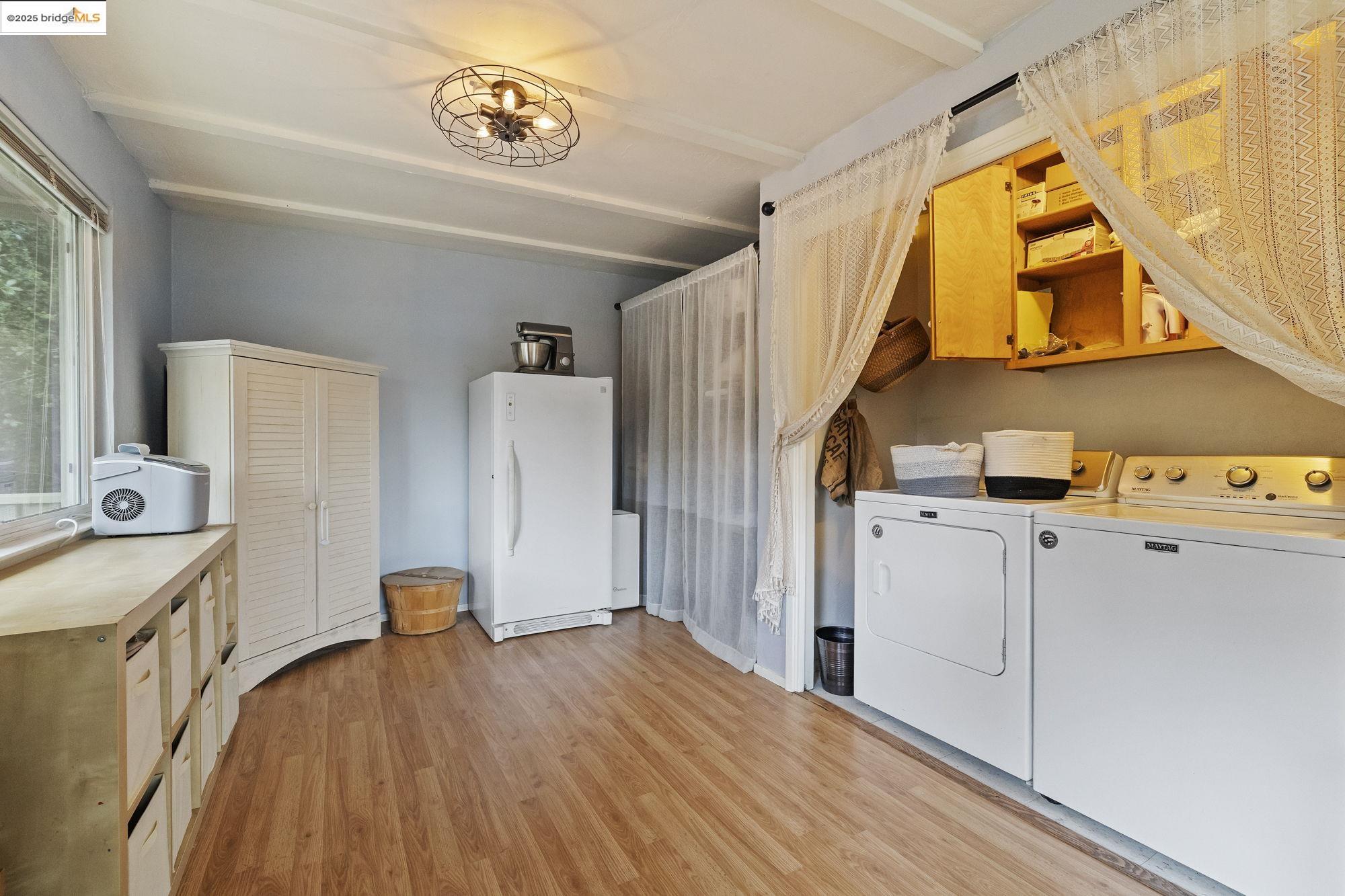 20638 Maranatha Road Tuolumne, CA 95379 - Photo 32 of 60 Laundry area featuring washing machine and clothes dryer, light wood-type flooring, and beam ceiling