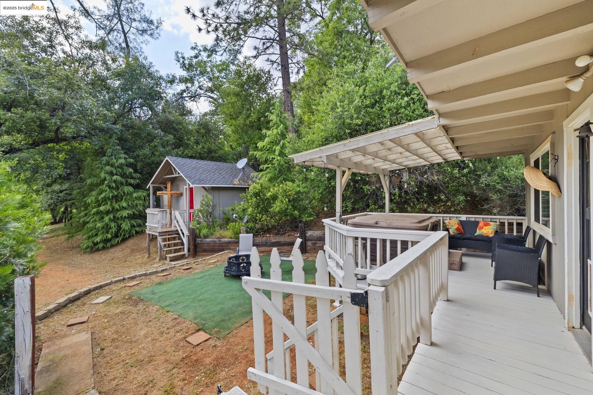 20638 Maranatha Road Tuolumne, CA 95379 - Photo 51 of 60 Deck with view of wooded area and an outdoor living space with a fire pit