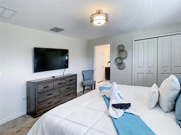 a kitchen with stainless steel appliances a refrigerator a sink dishwasher a stove a microwave oven a dining table and chairs with wooden floor