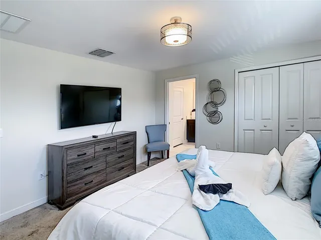 a kitchen with stainless steel appliances a refrigerator a sink dishwasher a stove a microwave oven a dining table and chairs with wooden floor