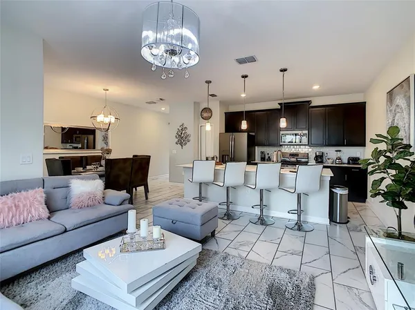 a living room with furniture a flat screen tv and a chandelier