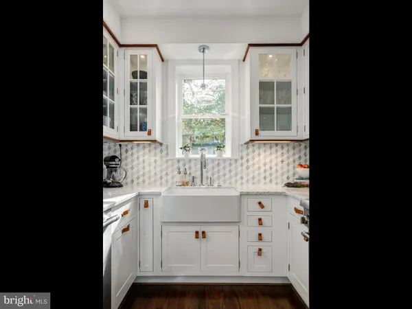 a kitchen with stainless steel appliances sink stove and white cabinets