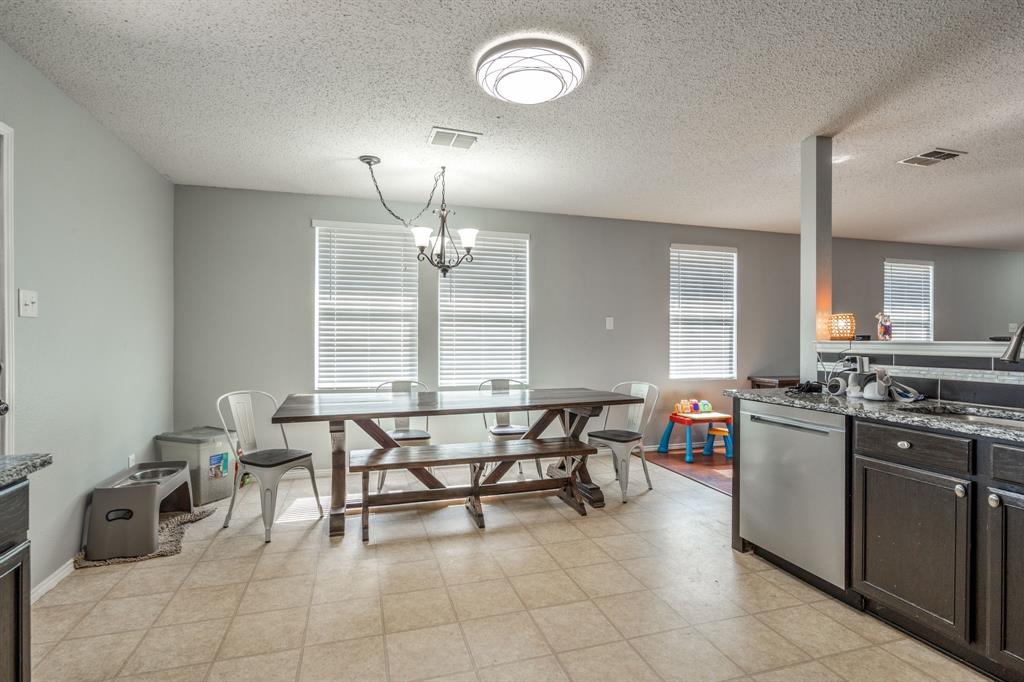 1973 Lariat Drive Fort Worth, TX 76247 - Photo 10 of 28 a kitchen with stainless steel appliances a stove a table and chairs