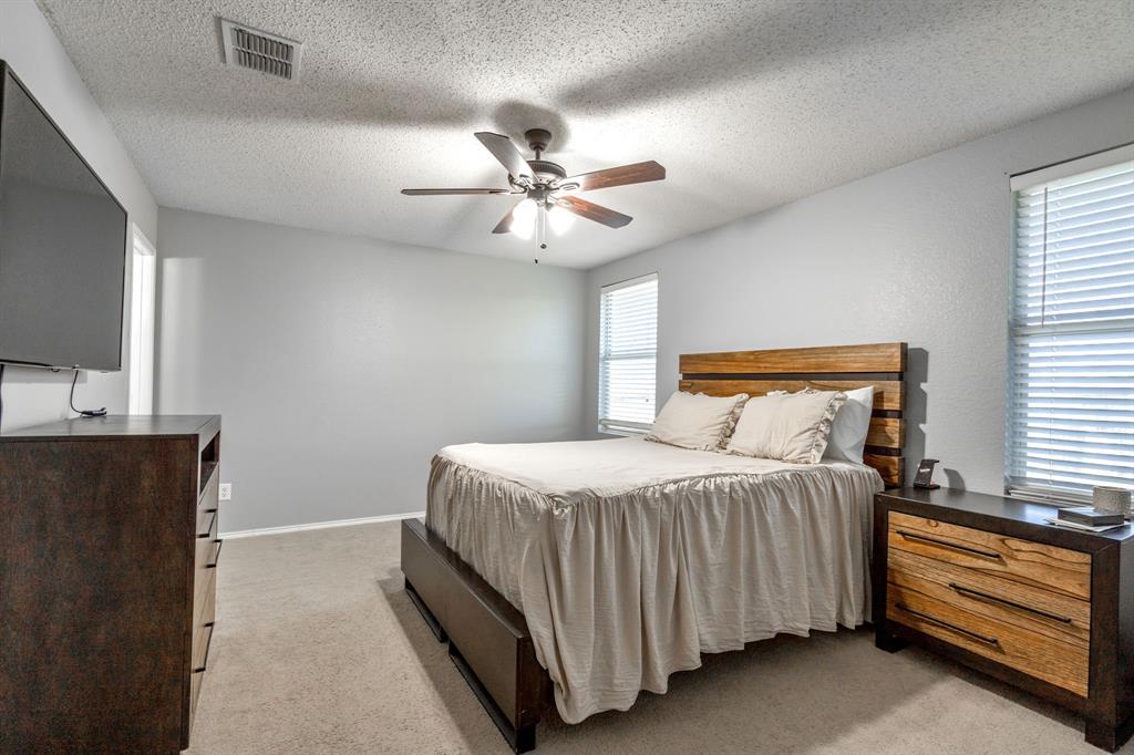 1973 Lariat Drive Fort Worth, TX 76247 - Photo 11 of 28 a bedroom with a bed and a ceiling fan