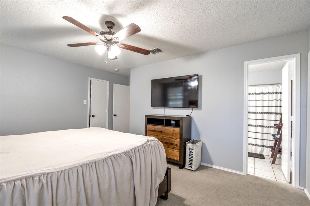 1973 Lariat Drive Fort Worth, TX 76247 - Photo 13 of 28 a bedroom with a bed and a flat screen tv