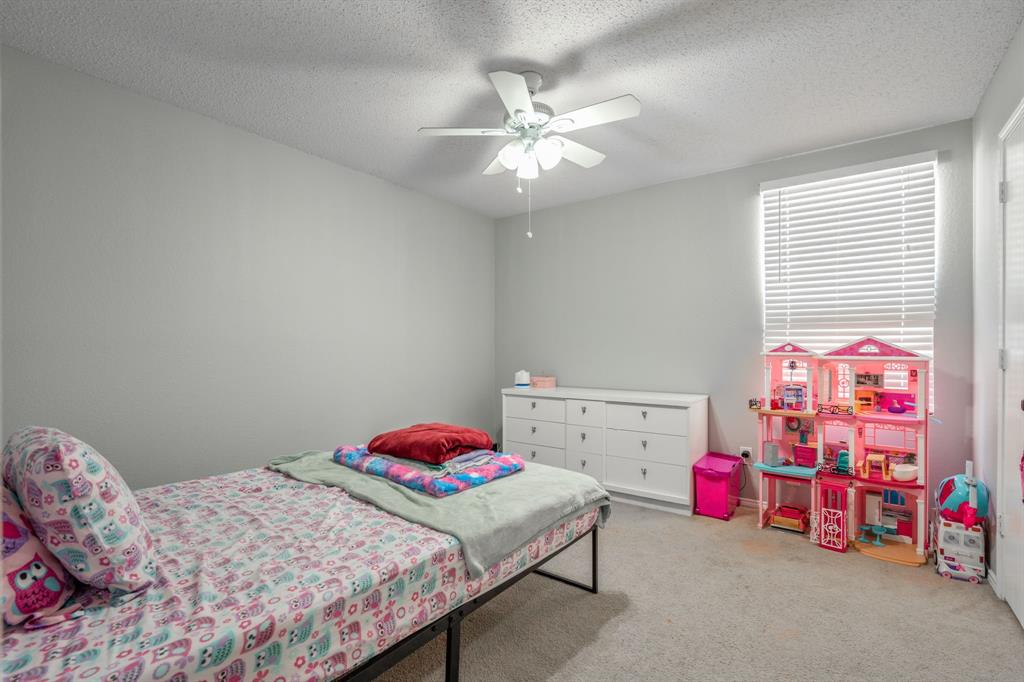 1973 Lariat Drive Fort Worth, TX 76247 - Photo 15 of 28 a bedroom with a bed a chandelier and closet