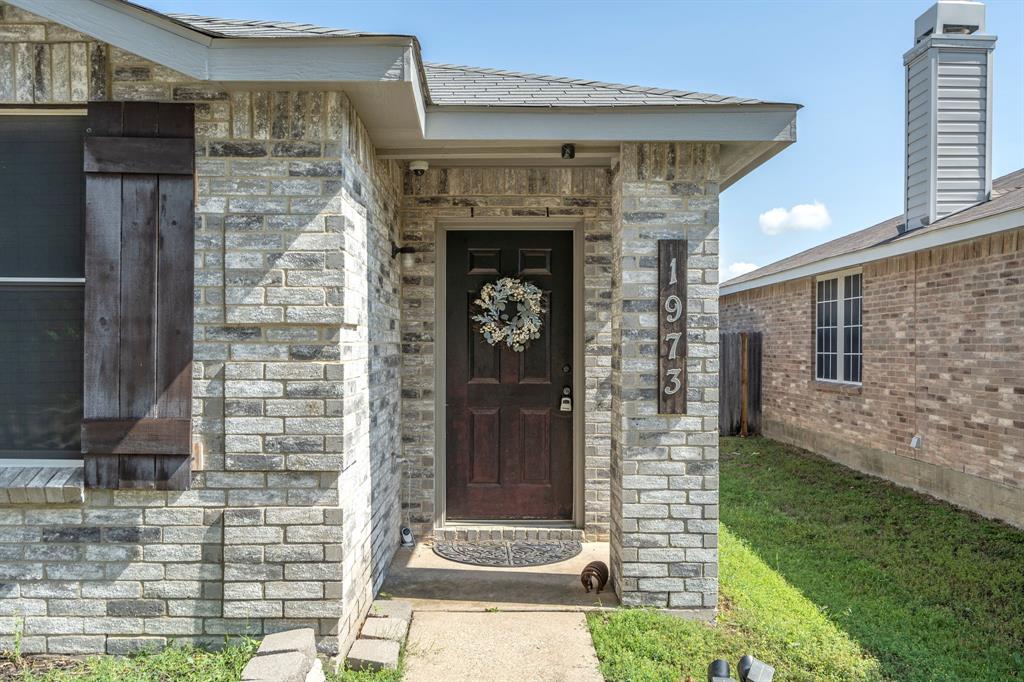 1973 Lariat Drive Fort Worth, TX 76247 - Photo 3 of 28 a front view of a house with garden