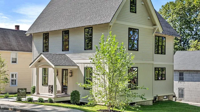 a front view of a house with a yard and tree s
