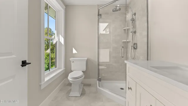 a bathroom with a granite countertop sink a toilet and shower
