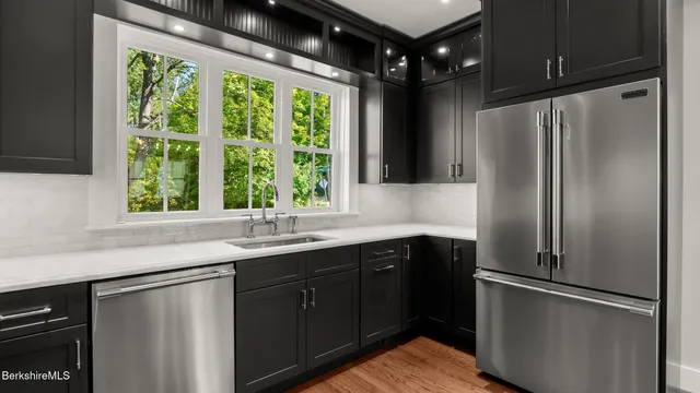a kitchen with stainless steel appliances a refrigerator sink and cabinets