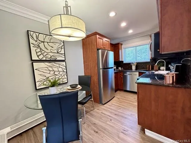 a kitchen with stainless steel appliances a refrigerator a sink a stove and a wooden floors