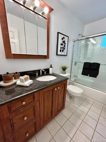 a spacious bathroom with a granite countertop sink and a mirror