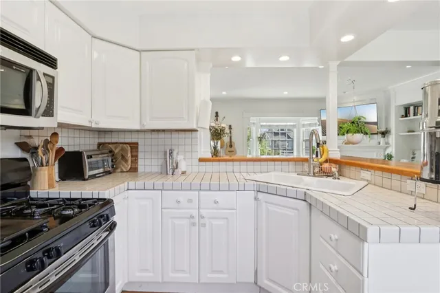 a kitchen with white cabinets and appliances