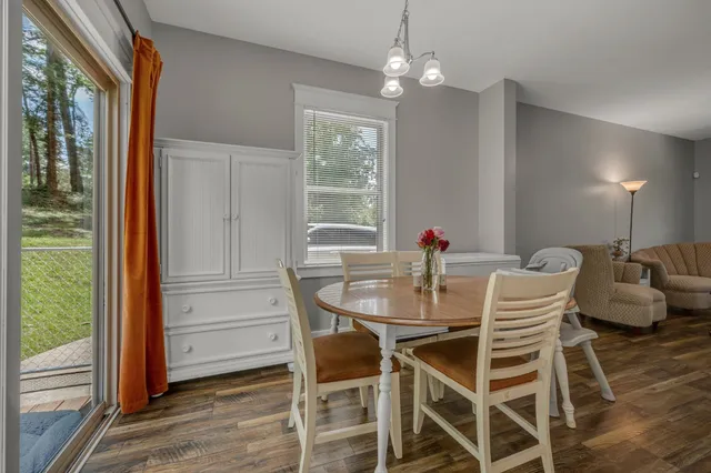 a dining room with furniture a chandelier and wooden floor