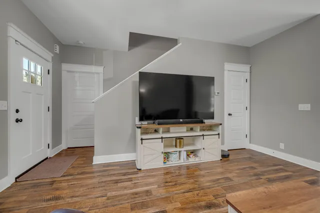 a living room with flat screen tv and wooden floor