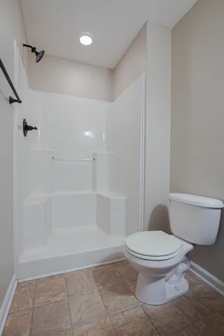 a white toilet sitting next to a bath tub