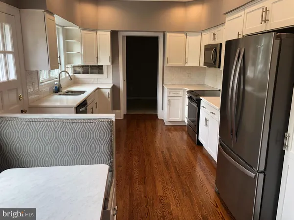 a kitchen with stainless steel appliances a refrigerator and wooden floor