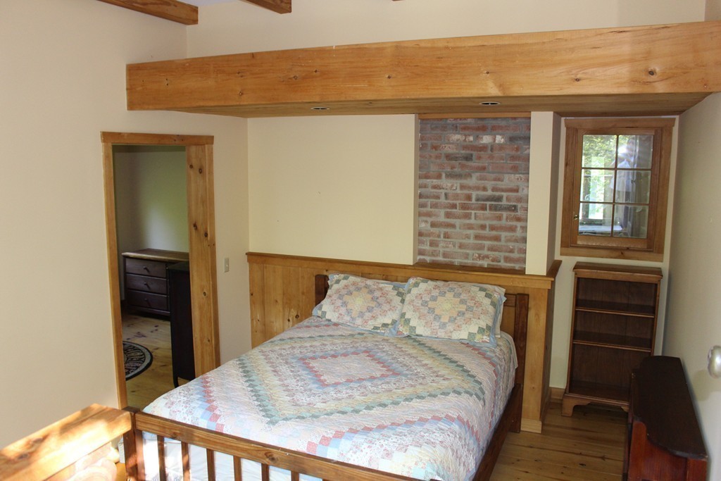 350 March Road Ashfield, MA 01370 - Photo 18 of 30 a bedroom with a bed and wooden floor