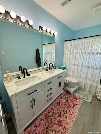 a spacious bathroom with a double vanity sink and a mirror