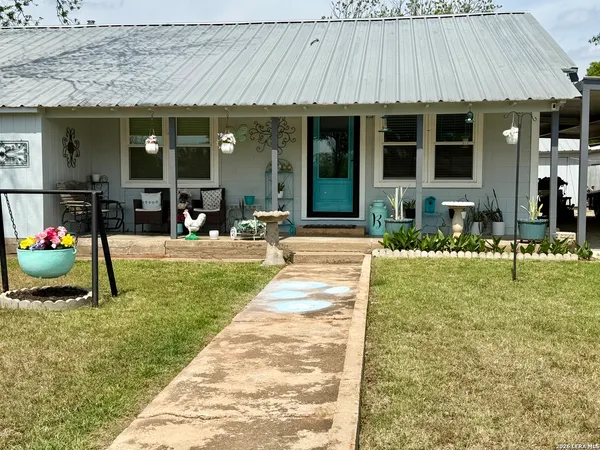 a view of a house with a patio and a yard