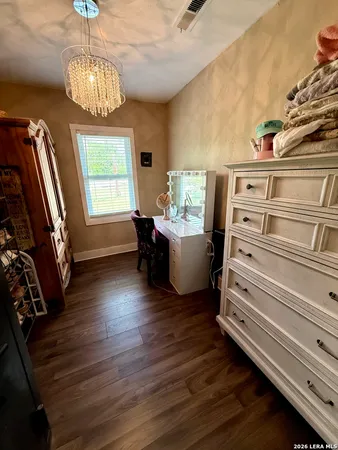 a view of a livingroom with wooden floor and furniture