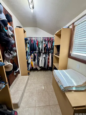 a view of walk in closet with clothes and shoes