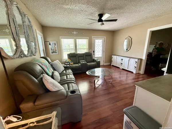 a living room with furniture a ceiling fan and a window