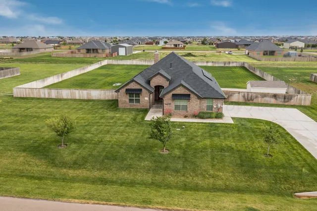 an aerial view of a house with a yard