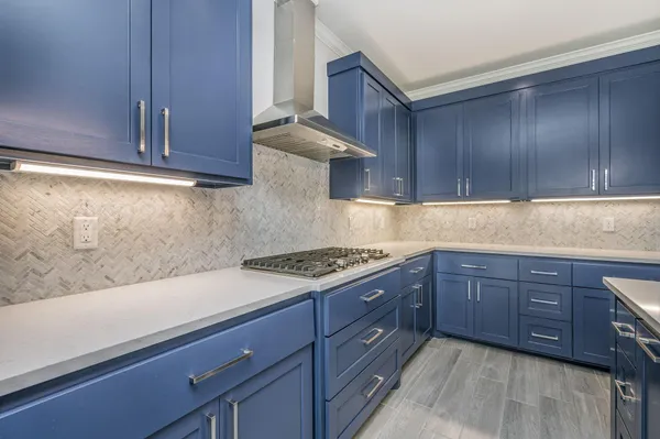 a kitchen with stainless steel appliances granite countertop wooden cabinets a stove and a sink