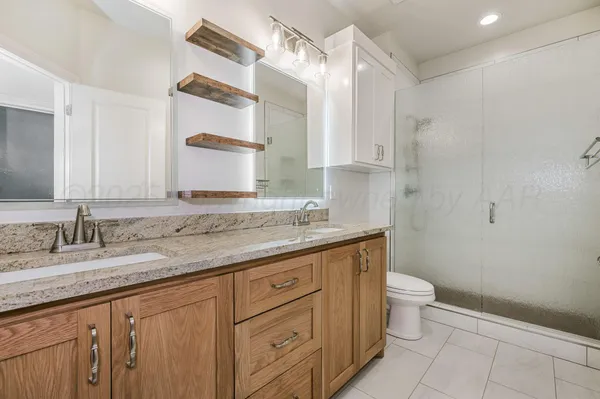 a bathroom with a granite countertop sink a toilet and a mirror